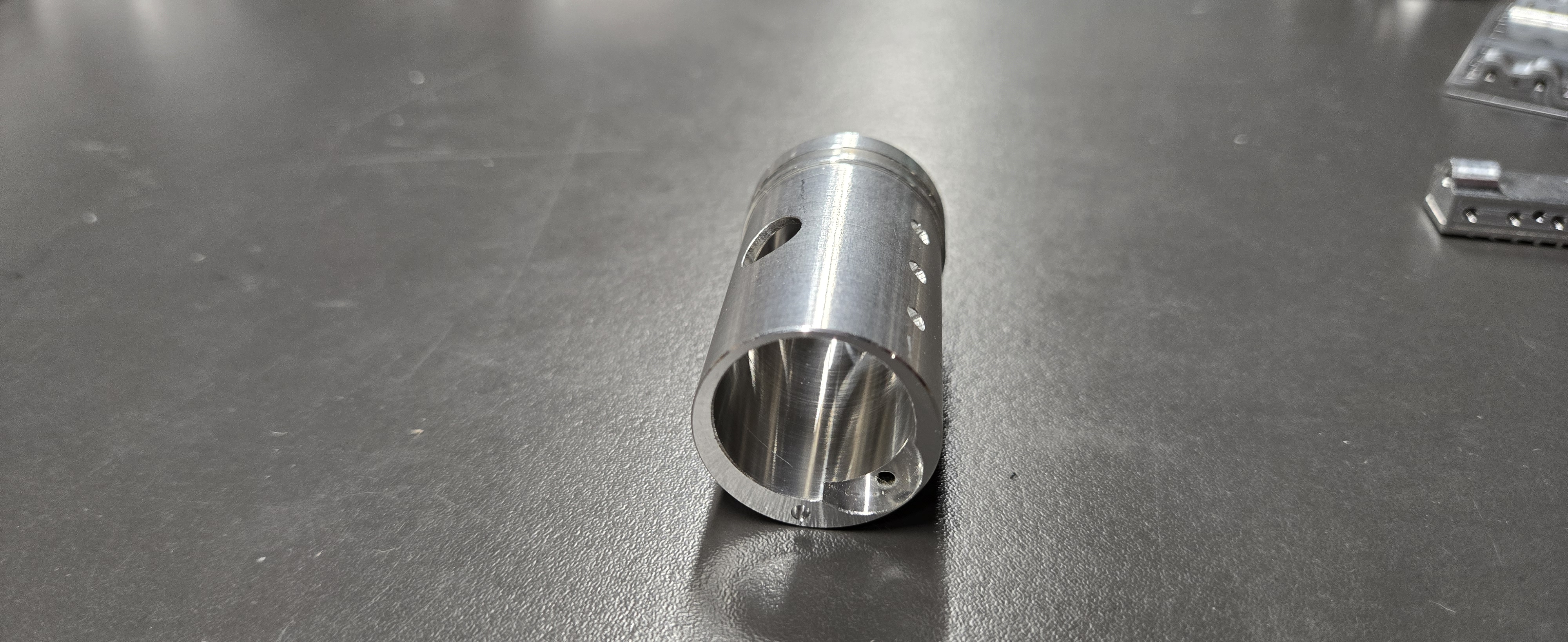 Precision turned aluminum bushing with cross-drilled holes